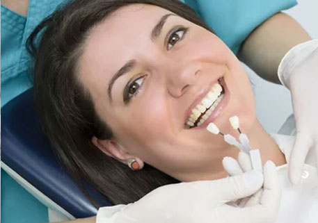 Patient comparing veneer shades during cosmetic dental consultation in Langley, BC